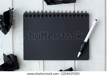Note book with black pages with a pen