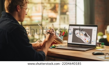 Inspired Blonde Man Creating Custom Made Model of Shoes and Looking at 3D Prototype Made in Editing Software on his Laptop. Art and Unique DIY Objects For Personal Style Concept.