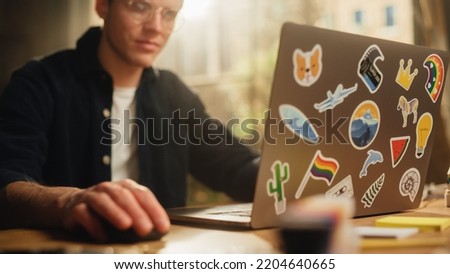Focused Male Software Engineer Codding on Laptop Computer and Working With Inspiration in Modern Loft Flat. Man Creating New Mobile Application. Freelancer Doing Remote Work.