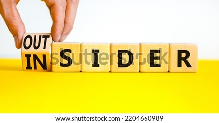 Insider or outsider symbol. Businessman turns wooden cubes and changes the concept word Insider to Outsider. Beautiful yellow table white background. Business insider or outsider concept. Copy space. Royalty-Free Stock Photo #2204660989