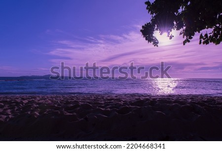Nature at dusk, includes the dawn over the ocean and the lovely beach. Sunset at a beach with blue sea and purple sky.
