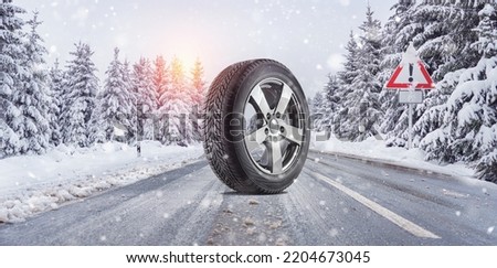 close up winter tires on a snowy road in the mountains - snow storm  Royalty-Free Stock Photo #2204673045