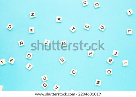 Random letters on a blue background. Scattered English alphabet. Abstract minimalist background