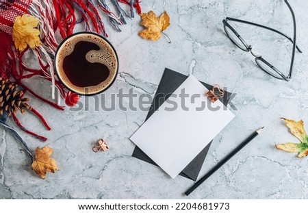 Red and gray autumn flat lay composition. Cup of coffee, plaid, pumpkin shaped candles, autumn leaves on gray marble background. Flat lay, top view