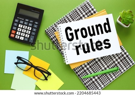 ground rule - yellow notepad with text on white paper on a green background