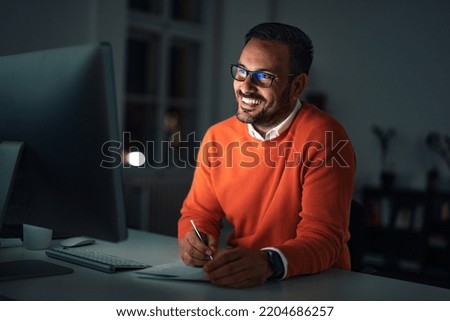Smiling man signing some contracts while talking to one client online.