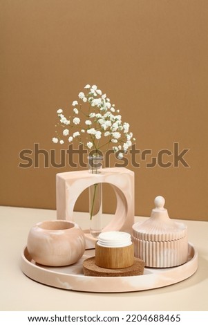 Jar of moisturizer cream and modern DIY concrete home decor on beige background.