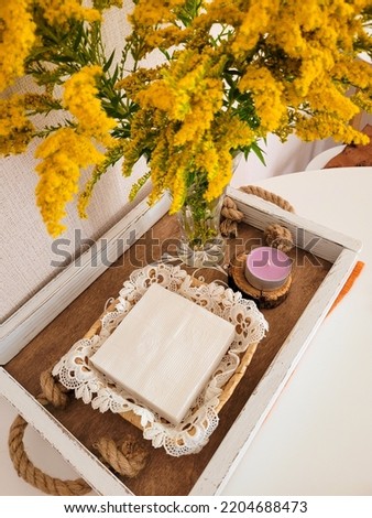 A tray with a candle and napkins, a vase of dry flowers on the table. Home interior.