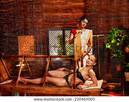 Woman having Ayurvedic sauna treatment.