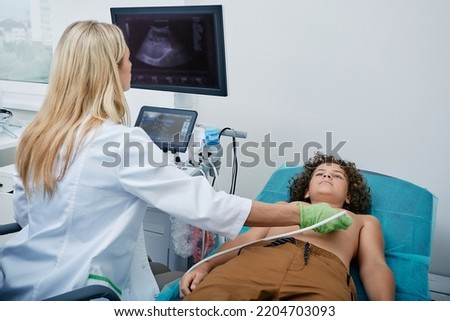 Heart ultrasound exam for male child with ultrasound specialist while medical exam at hospital