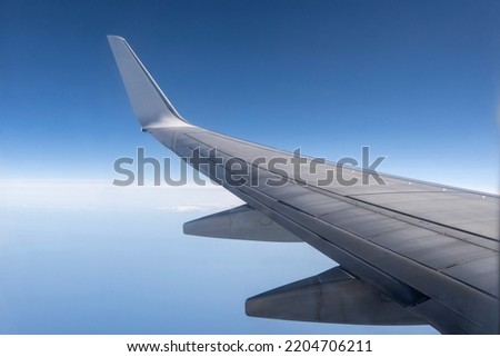 View from the inside or interior of the airplane. Airplane porthole window view from the passenger seat Royalty-Free Stock Photo #2204706211