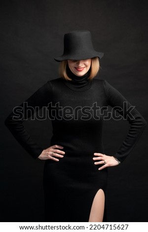 Confident woman in black dress on background
