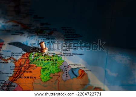 The wooden pin marking Caracas, the capital city, on the map with shadows spreading round the country. Concept a travel from this part of world with a warmer temperature and news event.