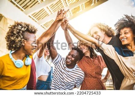 Multiracial happy young people putting their hands on top of each other - Diverse friends unity togetherness in volunteer community - Concept about college, relationship, creative, youth and community Royalty-Free Stock Photo #2204725433