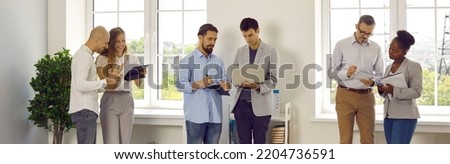 Working atmosphere in office. Three teams of office workers colleagues are talking, discussing and solving work issues during routine office life. Concept of business people. Panoramic web banner. Royalty-Free Stock Photo #2204736591