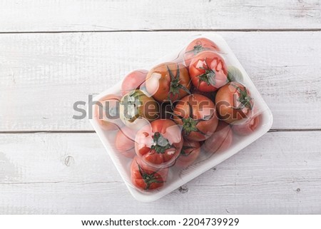 tomatoes packed in a plastic container on white