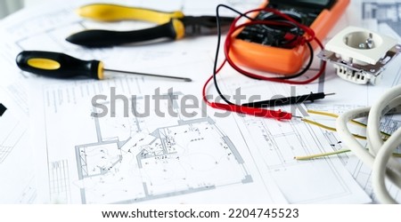 Making repairs,planning electricity project in house.Drawings,diagrams,plan for electrification of apartment, building. Devices and accessories, voltmeter, wires, screwdriver, pliers and tape measure. Royalty-Free Stock Photo #2204745523