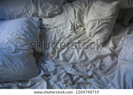 comfortable unmade bed with texture and pillows