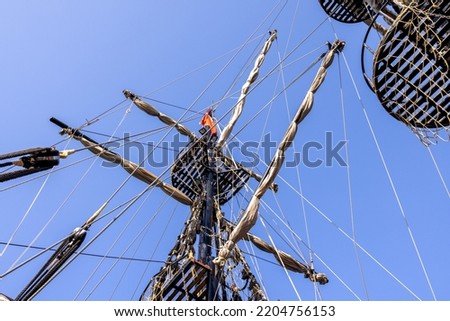 Photo looking straight up on a pirate ship showing the ships masts and ropes. Royalty-Free Stock Photo #2204756153