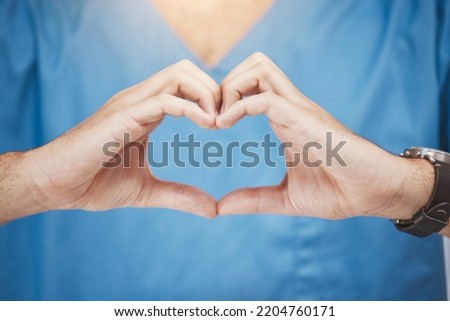 Doctor or nurse make heart sign, with hands to show care or compassion. Woman worker in healthcare show love icon with fingers, as expression of love for their job or wellness of patients Royalty-Free Stock Photo #2204760171