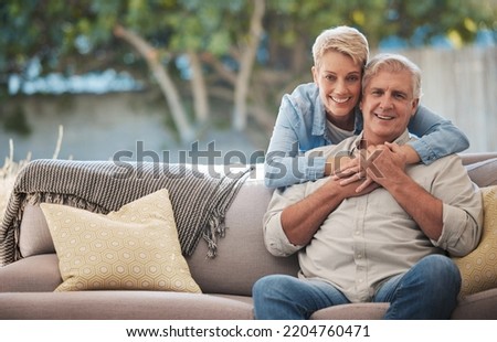 Mature couple, love bond and hug on house patio, home garden sofa and relax furniture chair in backyard. Portrait of smile, happy and retirement senior or man and woman in trust, security and safety
