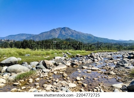 Landscape image in  sunlight with river, stones, trees, mountains Royalty-Free Stock Photo #2204772725