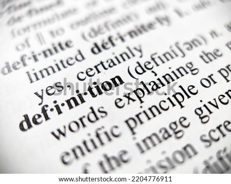 Dictionary definition word defined on a paper page with focus blur Royalty-Free Stock Photo #2204776911