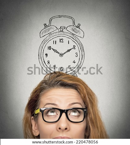 closeup headshot young business woman with alarm clock drawing sketch above her head, isolated grey wall background. Human face expressions, emotions. Time, punctuality, busy schedule concept