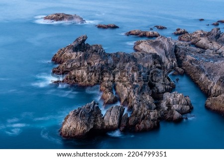 Long exposure of sea and rocks. Waves splashing on the rock creating a beautiful picture. Beautiful colours at sunset. Asturias Landscape - North of Spain. 