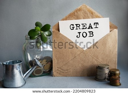 GREAT JOB text is written on white paper on an antique envelope, which lies on the table along with a stack of coins, a glass jar of coins and a sprout. 