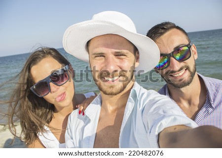 Group of friends taking picture in the beach