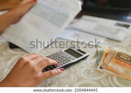 Housewife woman calculate energy invoice bills costs,family expenses price crisis Royalty-Free Stock Photo #2204844445