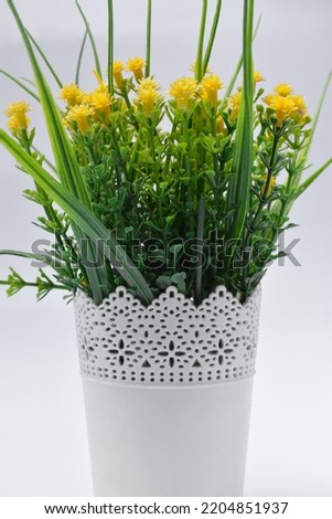 Plastic yellow flowers in pots home decoration isolated on white background