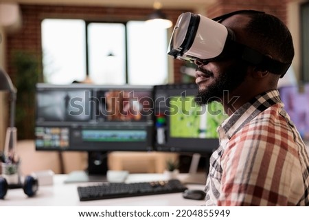 Male videographer using vr glasses to edit video, working on post production montage with virtual reality headset and creative software on computer. Content creator making film or movie.