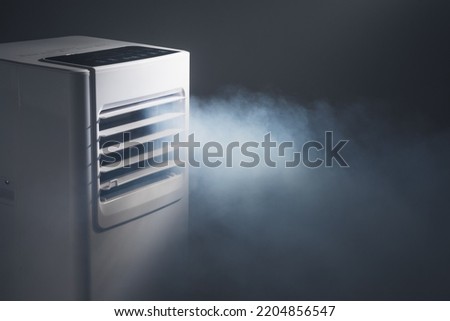 louvers outlet of portable air conditioner with cold steam, close-up view Royalty-Free Stock Photo #2204856547