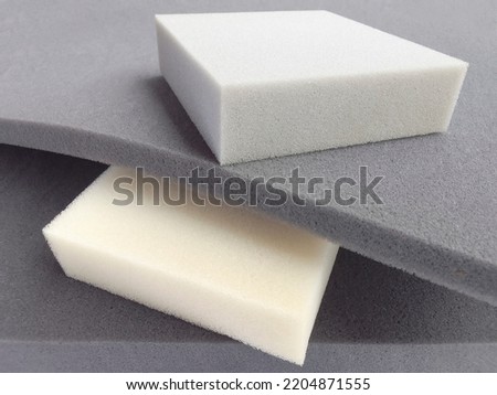 rectangular pieces of gray and white foam sponge neatly stacked. materials with different thickness