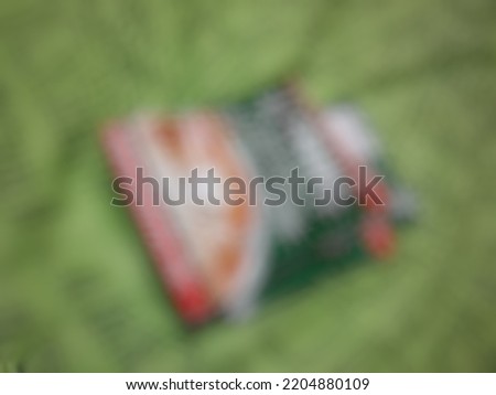 Defocused or blurred abstract background of one sachet of coffee on the green bedsheet. This product is locally made in Indonesia