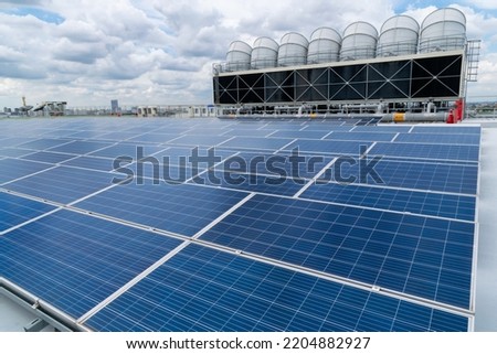 Hot climate and Sets of cooling towers cause increased power production,Alternative energy to conserve the world's energy, rooftop solar and cooling systems. Royalty-Free Stock Photo #2204882927