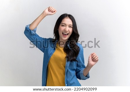 Studio portrait photo of young beautiful Asian woman in colorful casual clothing feeling joyful and relaxing dancing and smiling studio photo shoot on white background. People emotion portrait concept