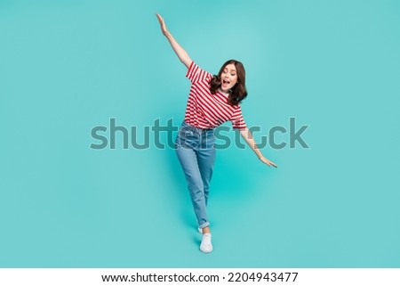Full length photo of nice crazy lady go rope balancing hand dressed striped clothes look empty space isolated on cyan color background Royalty-Free Stock Photo #2204943477