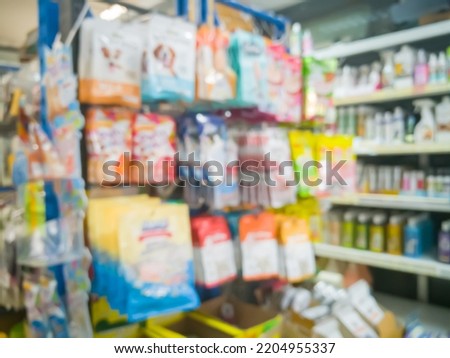 Blurred picture of various animal feed products or dry food, biscuit, snack, chew bone for dog and cat in plastic box on shelf in pet food store