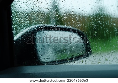driving car on road in the rain with raindrop over the wind shield, traffic jam in rainy season