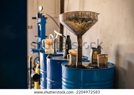 Used engine oil collection in a workshop, used oil barrel Royalty-Free Stock Photo #2204972583