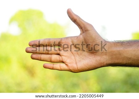 A Asian Pakistani man showing and pointing up with five fingers. Asian Man showing hand's gestures. Five fingers gesture of hand. With selective focus on the subject.