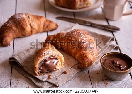 Delicious chocolate croissants  fruit for breakfast on rustic wooden table
