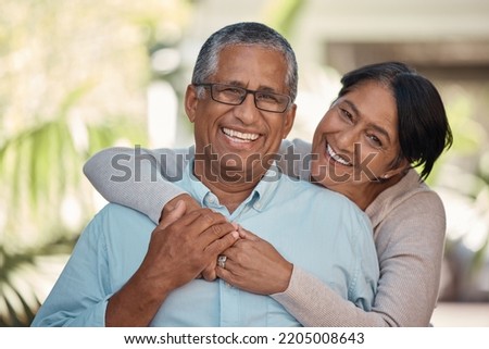 Portrait of an elderly couple hugging and bonding outdoors, happy and relaxing in a yard or garden together. Senior man and woman enjoying retirement and a peaceful morning on a patio at home