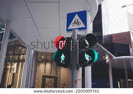 Signs bicycle crossing road and bicycle light on bicycle lane in Singapore.