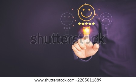 Man touching the virtual screen on the happy smiley face icon to give satisfaction in service. Rating very impressed. Customer service, testimonial satisfaction concept. Royalty-Free Stock Photo #2205011889