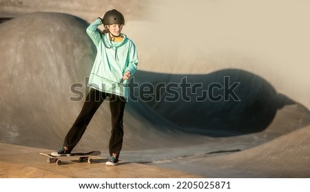 young teen girl having fun and practicing in a skate park, urban background, healthy active lifestyle. High quality photo