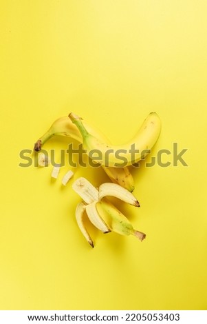 some bananas and banana slices on a yellow background with copy space, selective focus, isolated, flatlay